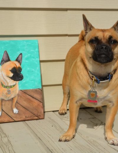 dog standing next to his portrait